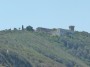 Gita in barca a Baratti, Piombino (LI) - Il castello fortificato di Populonia con la sua torre merlata. Sulla sinistra si scorge il faro di Populonia. Tale faro indica il confine fra il Mar Ligure ed il Mar Tirreno - Fotografia 8 luglio 2012, Toscana